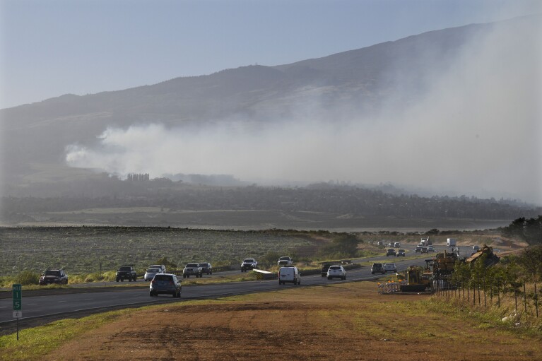Smoke blows across the slope of Haleakala volcano on Maui, Hawaii, as a fire burns in Maui's upcountry region on Tuesday, Aug. 8. 2023. Several Hawaii communities were forced to evacuate from wildfires that destroyed at least two homes as of Tuesday as a dry season mixed with strong wind gusts made for dangerous fire conditions. (Matthew Thayer/The Maui News via AP)